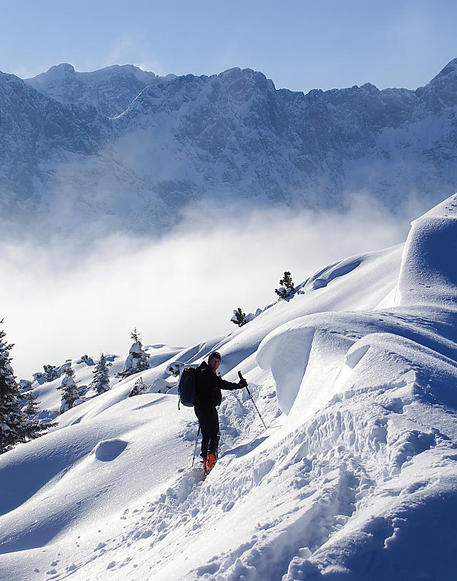 Skitourengeher auf unberührtem Schneefeld in Flachau bei Sonnenschein